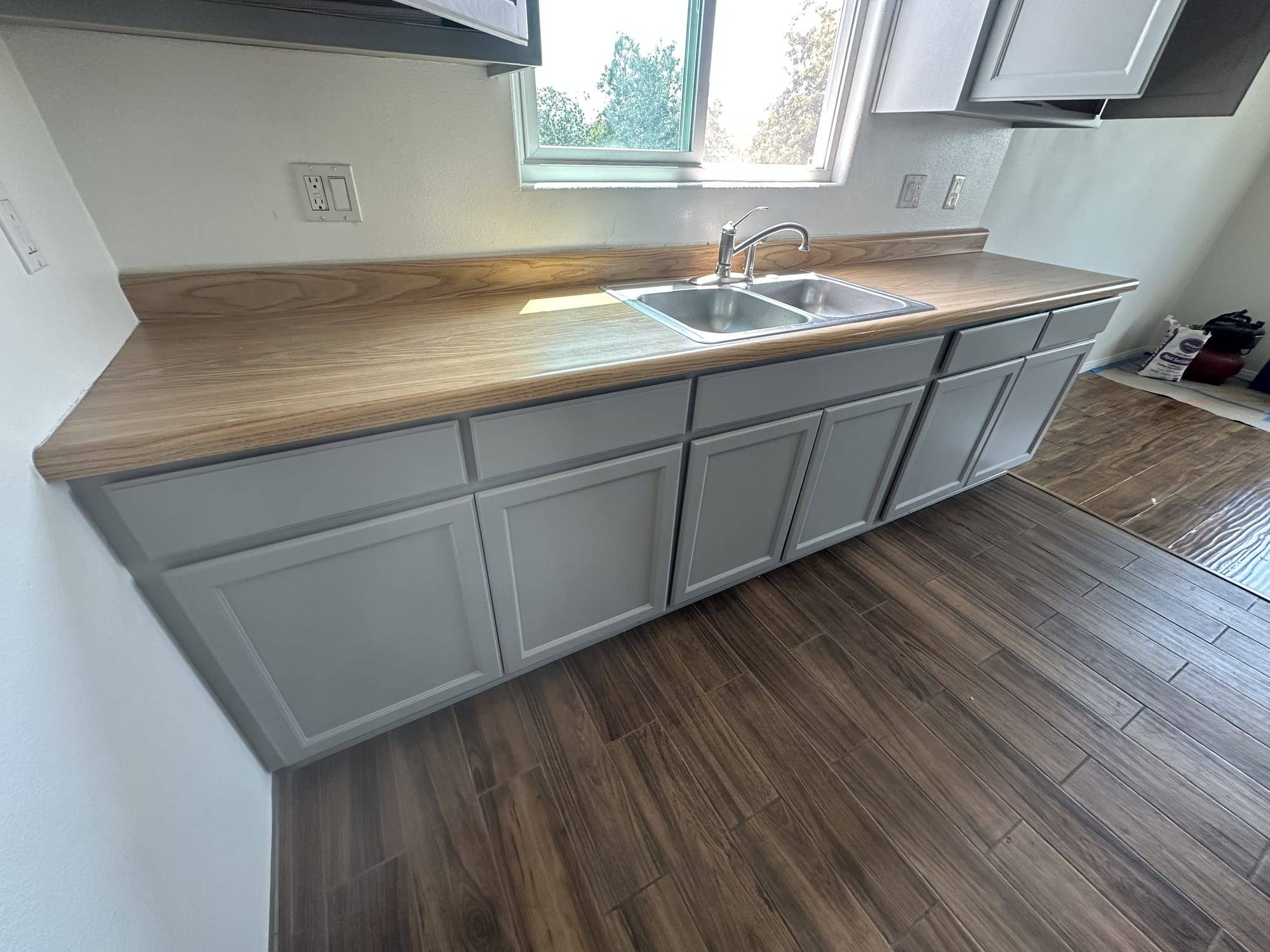 Gray painted base cabinets with a wood countertop