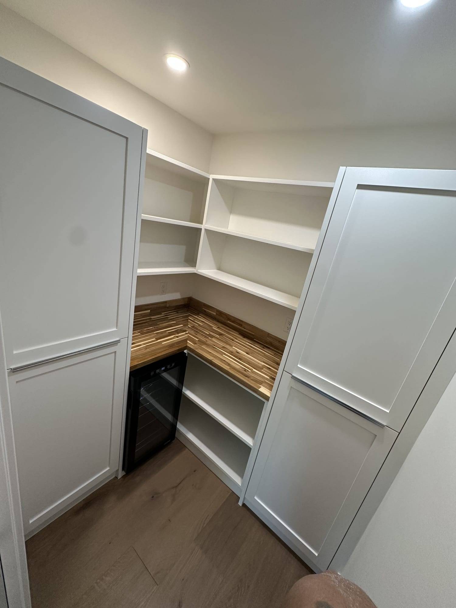 Gray painted pantry doors with white shelves, angle view
