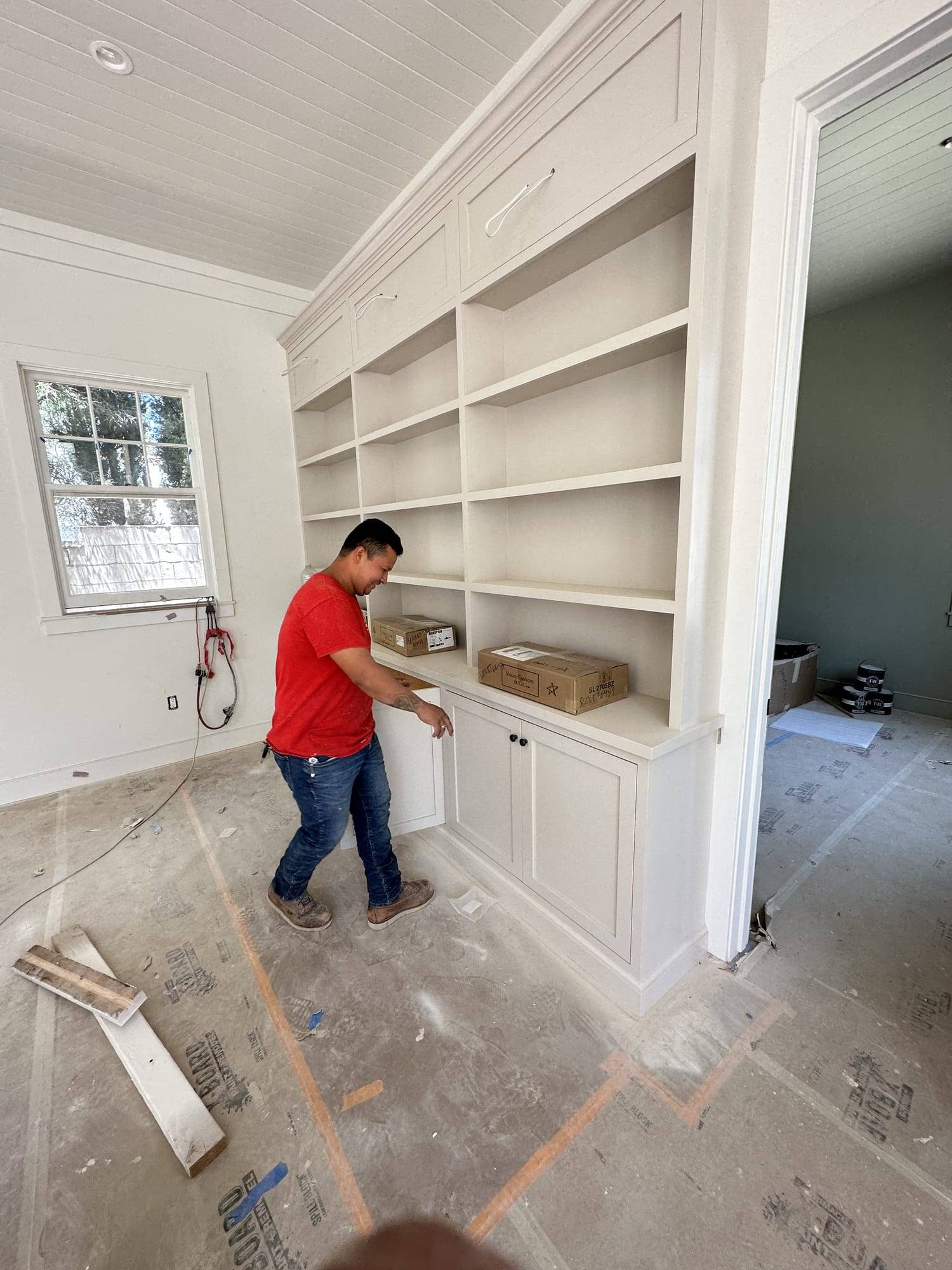 Painter working on a white built-in bookcase