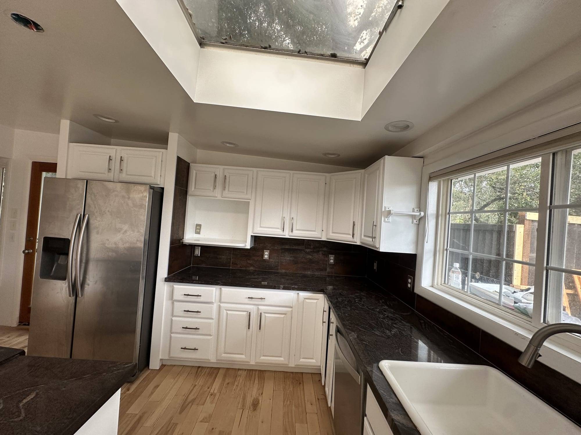 White painted kitchen cabinets with black countertops