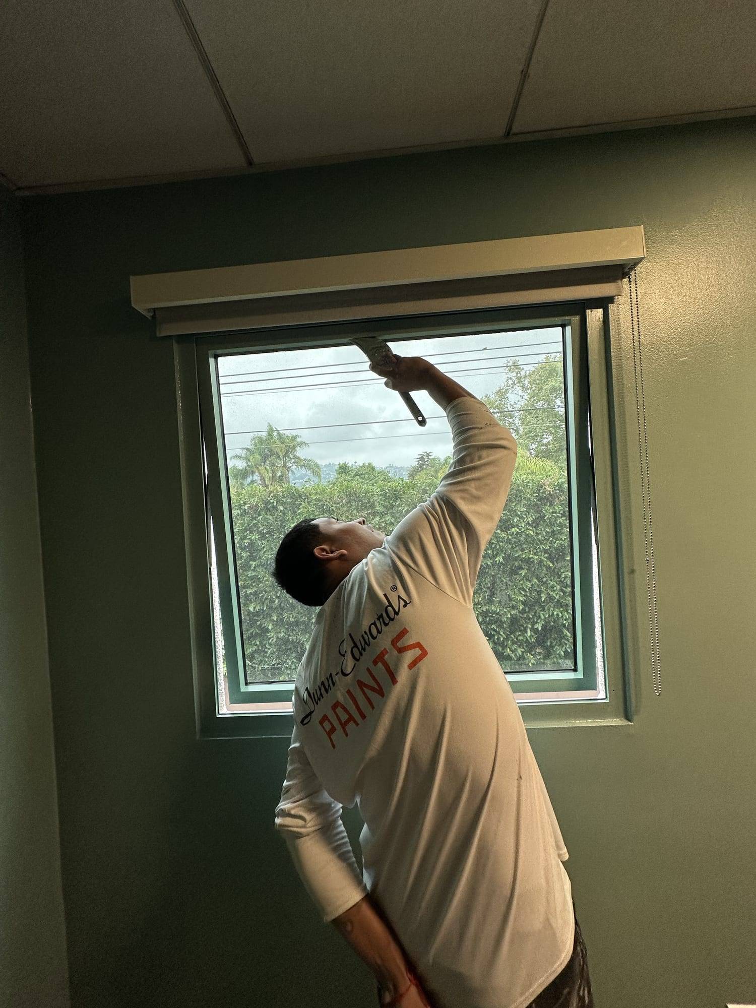 Painter working on office window trim