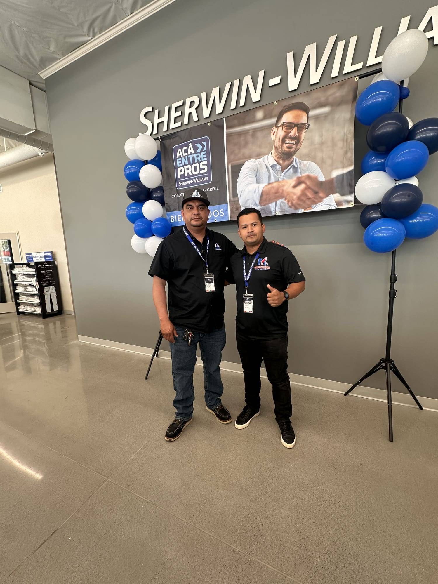 Two members of the Master's Pro Painting team at a paint store event