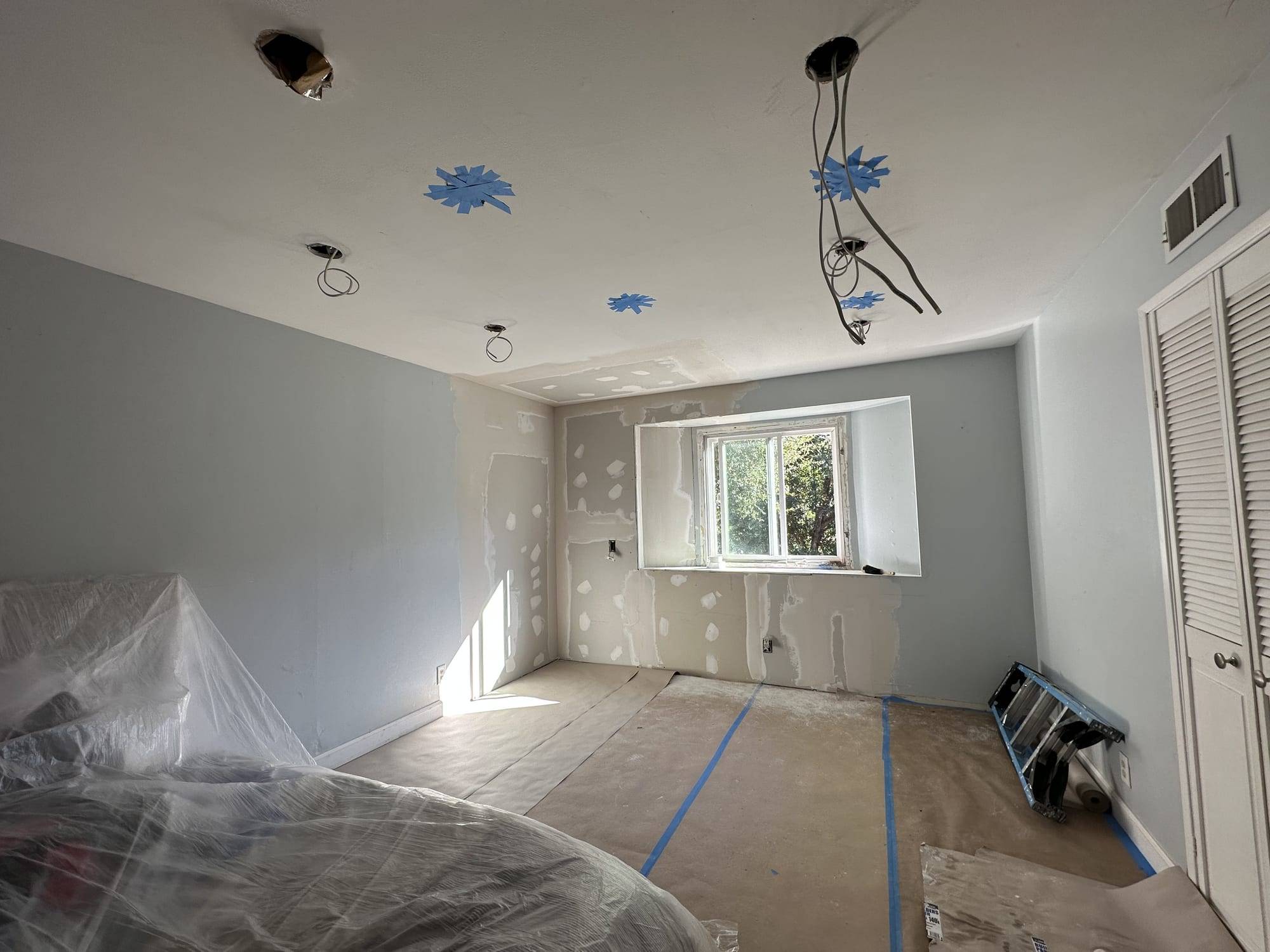 Drywall joints and ceiling openings patched around a window