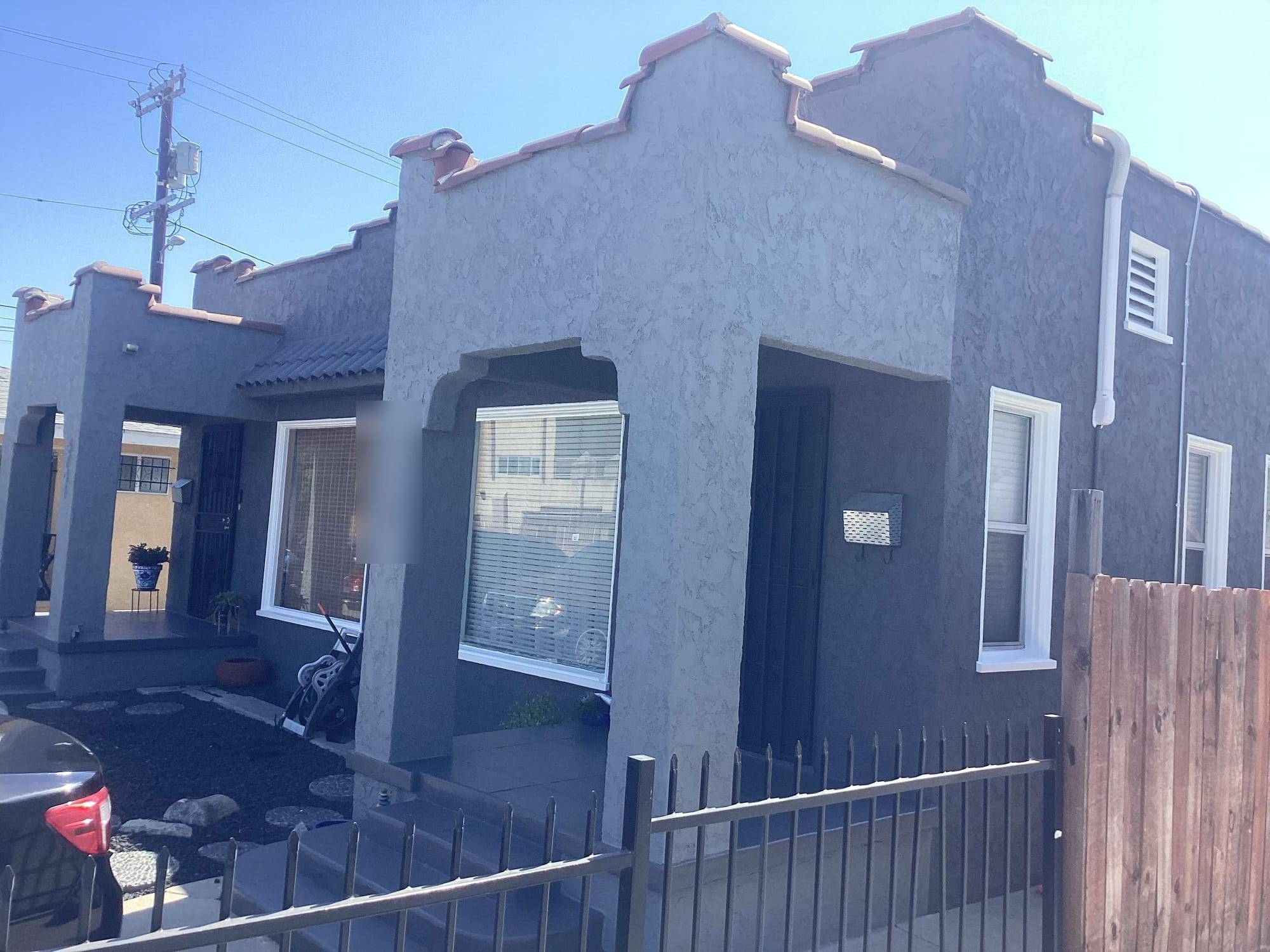 Spanish-style home repainted in charcoal gray stucco with white window trim