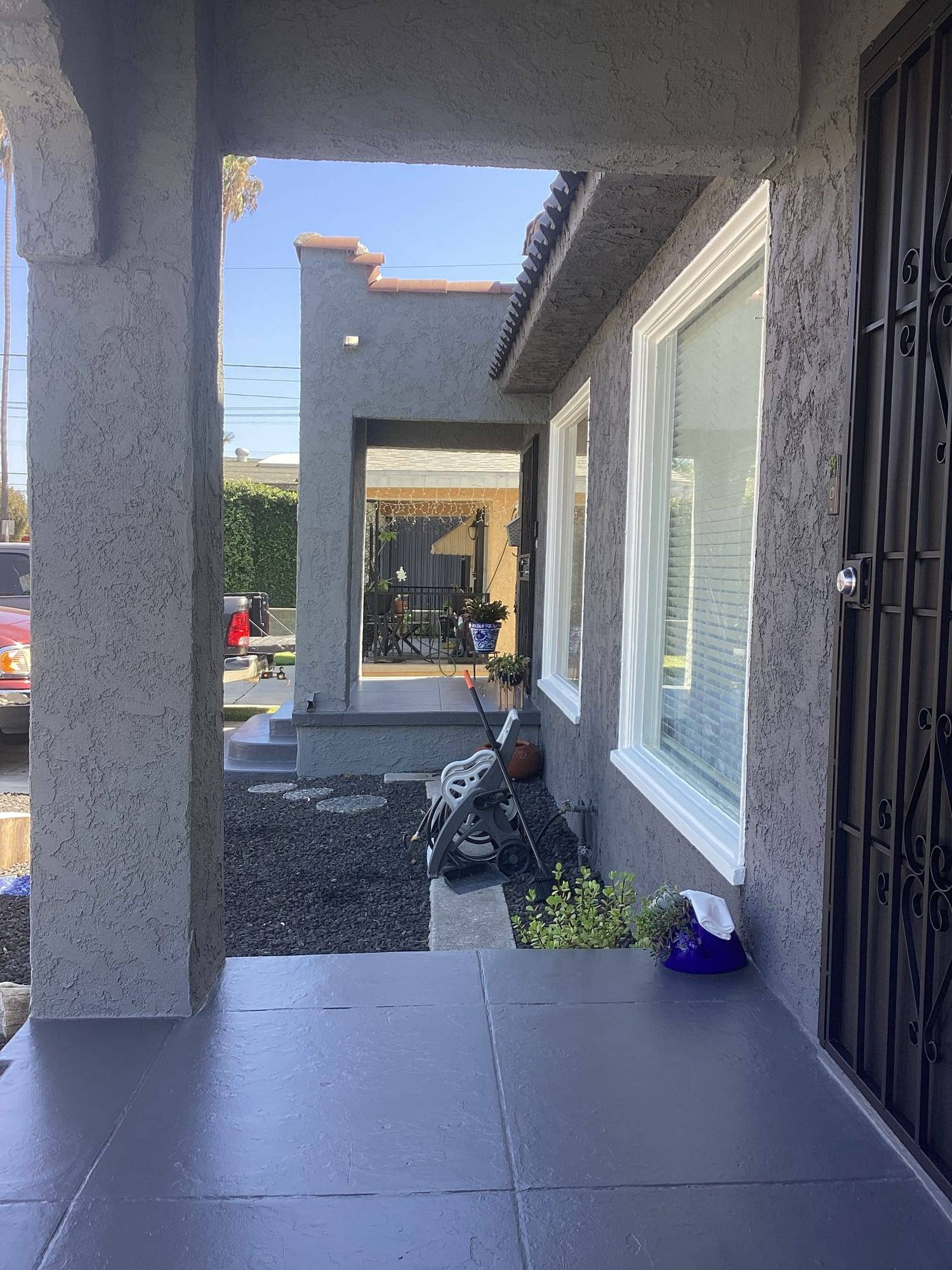 Gray stucco front porch with crisp white window trim