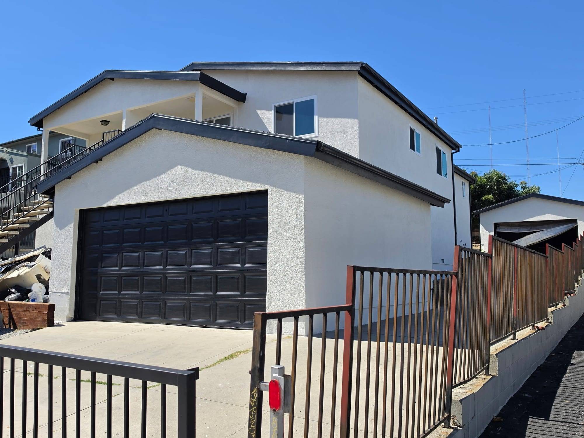 Repainted stucco building with a black garage door