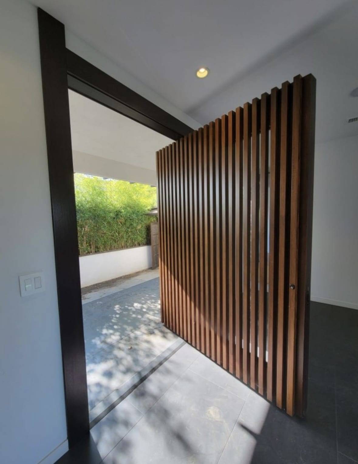 Slatted wood entry door with a natural wood finish, inside view