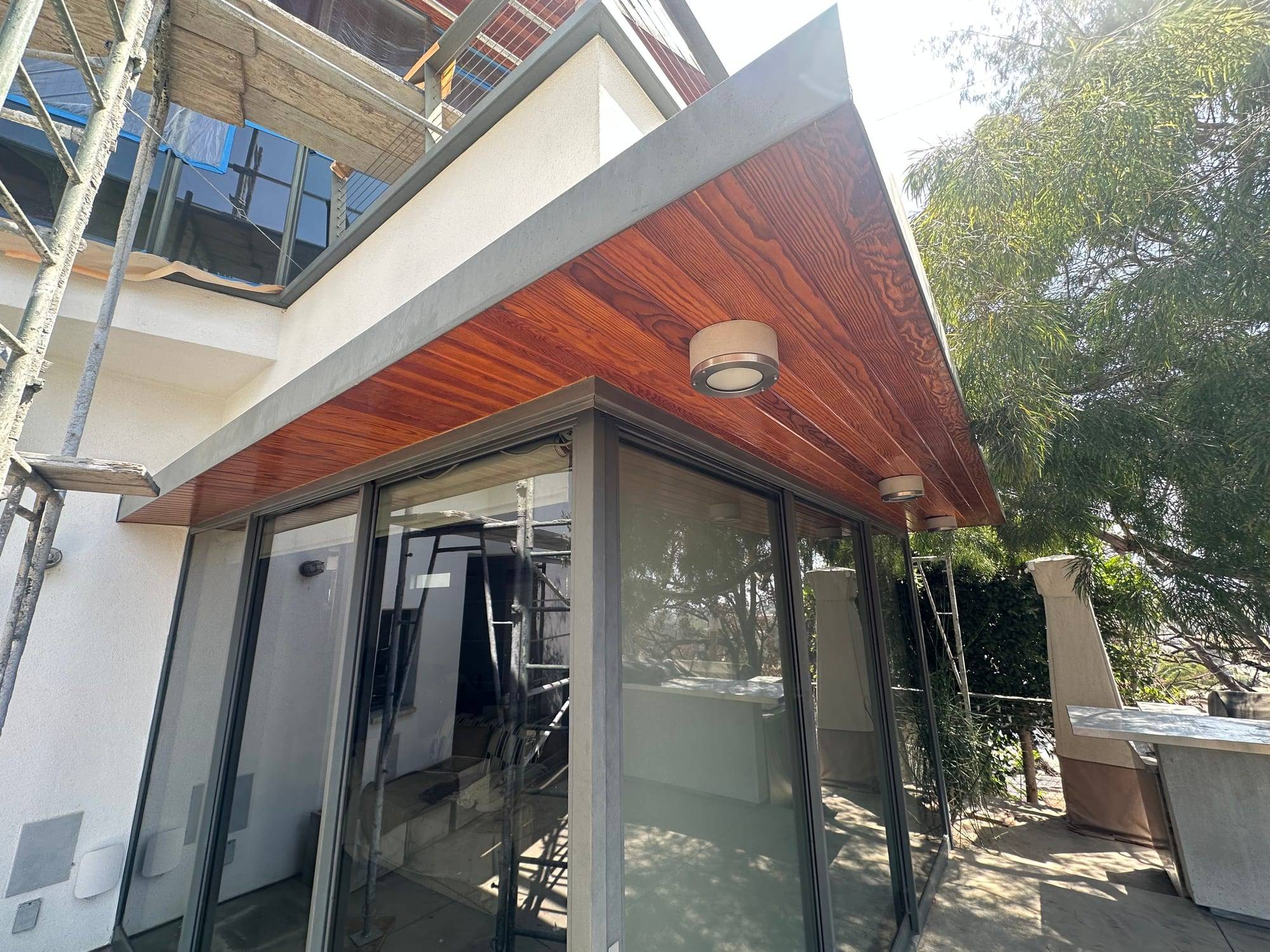 Stained wood soffit on a modern home with scaffolding still up